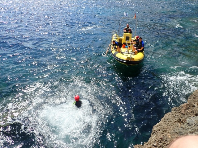 Zum Boot schwimmen nach dem Sprung von der Klippe